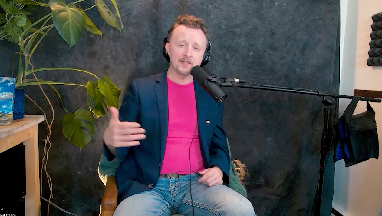 Actor Paul Cram wearing a bright pink shirt beneath a navy blue blazer